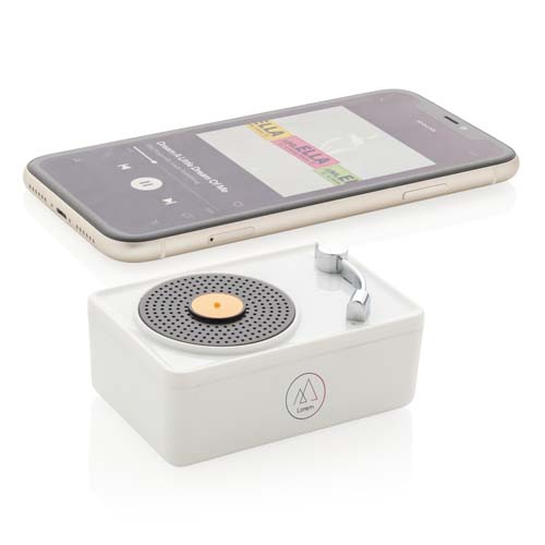 Smartphone con reproducción de música junto a un altavoz compacto de diseño retro tipo tocadiscos